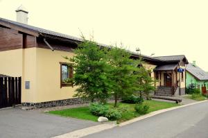 una casa con un árbol delante de una calle en Liptovska Izba en Liptovská Kokava