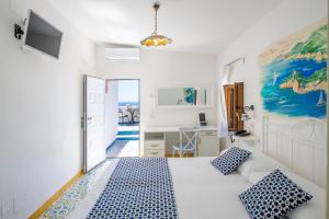 a bedroom with a bed with blue and white pillows at Hotel Costa Diva in Praiano