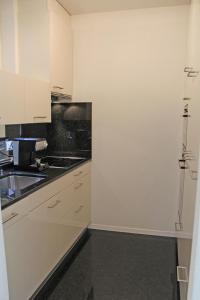 een keuken met witte kasten en een spoelbak bij Condominio Vorame by HolAp SA in Ascona