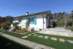 una piccola casa bianca con un prato di Casa Ermenegilda, 4,5-Zimmerhaus by HolAp SA ad Ascona