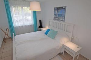1 dormitorio con cama blanca y almohada azul en Parco Fontile by HolAp SA, en Minusio