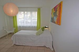 Un dormitorio con una cama y una ventana en Parco Fontile by HolAp SA, en Minusio