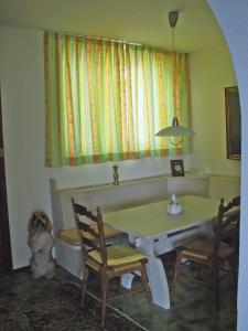 a dining room with a table and chairs and a window at Casa Martina, 4,5-Zimmerhaus by HolAp SA in Brissago