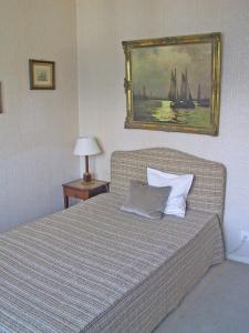 a bedroom with a bed with a painting on the wall at Casa Martina, 4,5-Zimmerhaus by HolAp SA in Brissago +1 photo