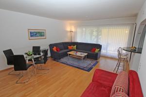 een woonkamer met een bank en een tafel bij Alle Vigne, 1 Stock by HolAp SA in Ascona +1 foto