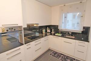 a kitchen with white cabinets and black counter tops at Casa ai Faggi, 3-Zimmerwohnung, 3 Stock by HolAp SA in Losone