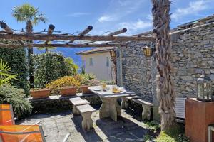 a patio with a table and a stone wall at Rustico Luna by HolAp SA in Brione sopra Minusio