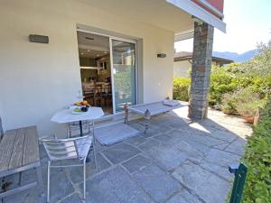 a patio with a bench and a table and chairs at Serendipita by HolAp SA in Losone