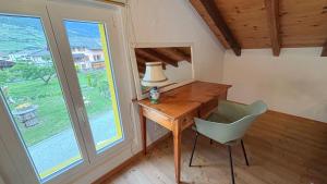 a desk and a chair in a room with a window at Charmante maisonnette avec jardin in Rechy