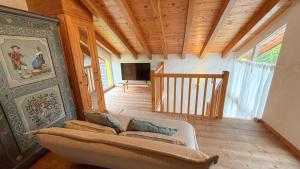 Una sala de estar con un sofá y un techo de madera. en Charmante maisonnette avec jardin, en Rechy