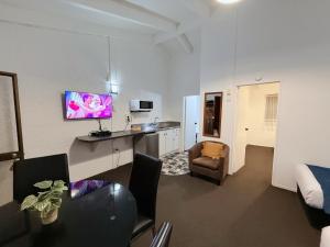 a living room with a table and a tv in it at Cortez Motel in Whakatane
