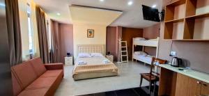 a bedroom with a bed and a couch and bunk beds at CityCenterHotel Shkoder in Shkodër