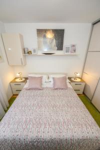 a bedroom with a large bed with pink pillows at Val in Kaštela