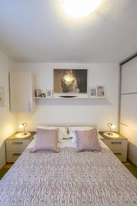 a bedroom with a large bed with two lamps at Val in Kaštela