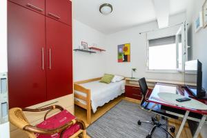 a bedroom with a bed and a desk with a computer at Val in Kaštela