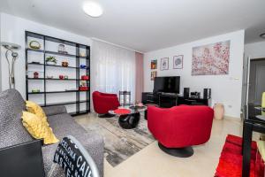 a living room with red chairs and a television at Val in Kaštela