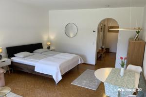 een slaapkamer met een groot bed en een tafel bij Residenza Sabrina 10 by Fewotessin in Ascona