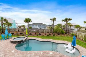 a backyard with a swimming pool and a yard with palm trees at Gratitude Island in Navarre