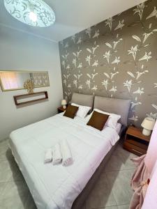 1 dormitorio con 1 cama blanca grande y zapatillas. en Casa Ponticello, en Termini Imerese