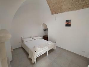 a white bedroom with a white bed in a room at Casa Vacanza Al Vicolo della Colonna nel centro storico di Presicce in Presicce