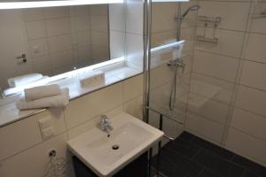 een badkamer met wastafel en douche met spiegel bij StrandGut inkl Saisonstrandkorb und Wäsche Set in Heiligenhafen +16 foto's