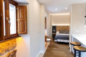a room with a bed and a room with a kitchen at La Barata Apartamentos in Colombres