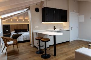 a room with a kitchen and a bedroom with a bed at La Barata Apartamentos in Colombres