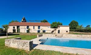 a house with a swimming pool in front of a building at Grange La Roca Masia in Assier