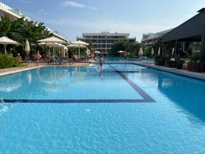 a large pool with blue water in a resort at Iskele Courtyard Long Beach Apartment in Iskele
