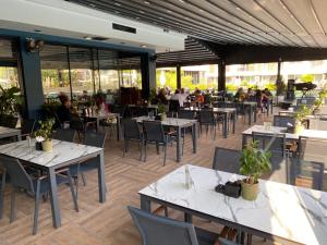 a restaurant with tables and chairs and people in the background at Iskele Courtyard Long Beach Apartment in Iskele