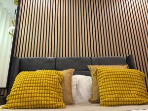 a bed with yellow pillows in front of a wall at Casa da Vila do Rock in Paredes de Coura +22 photos