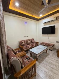 a living room with couches and a flat screen tv at Luxury Appartment Radha Kunj in Vrindāvan