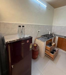a kitchen with a black refrigerator and a stove at Luxury Appartment Radha Kunj in Vrindāvan