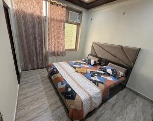 a bedroom with a bed with a comforter and a window at Luxury Appartment Radha Kunj in Vrindāvan