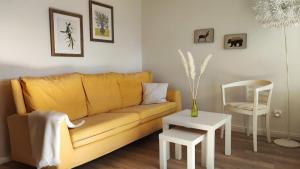 a living room with a yellow couch and a table at Chalet Flandesbach in Velbert