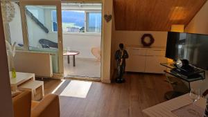 a man standing in a living room with a television at Chalet Flandesbach in Velbert +26 photos