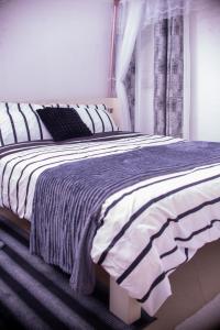 a bedroom with a bed with a blue and white blanket at Ronny Homes in Mombasa