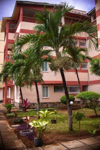 a building with palm trees in front of it at Ronny Homes in Mombasa