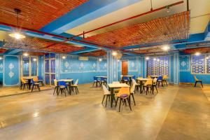 Habitación con mesas, sillas y paredes azules. en Townhouse Oak Alwar Railway Junction, en Alwar