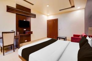 a bedroom with a bed and a desk and a tv at Townhouse Oak Lalghati Tekri Bhopal Viewpoint in Bhopal +20 photos