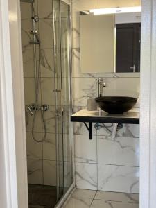 łazienka z przeszkloną kabiną prysznicową i umywalką w obiekcie Serenita verde Apartment w mieście Poros