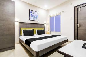 une chambre avec un grand lit dans une pièce dans l'établissement Townhouse Oak Dewas Junction, à Dewās