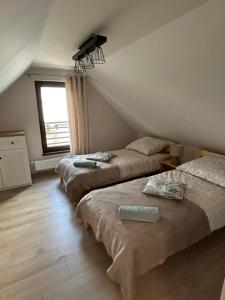 a bedroom with two beds and a window at Domowe Zacisze in Augustów