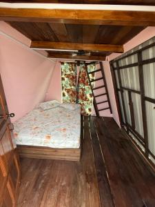 a small bed in the corner of a room at Redang Campstay A Frame in Redang Island