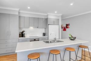 a kitchen with white cabinets and a counter with stools at Apres - Dog Friendly in Mansfield +5 photos