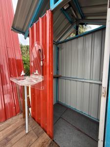 an open garage with a red door and a table at Redang Campstay A Frame in Redang Island