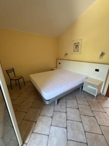 een slaapkamer met een bed en een stoel erin bij Residence IL BORGO 40 in Tortoreto Lido