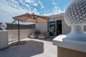 a patio with an umbrella and a couch at Da Felicia in Capo dʼOrlando