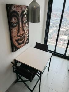 a table and chair in a room with a picture at The Base Central Pattaya by WWC in Pattaya Central +70 photos
