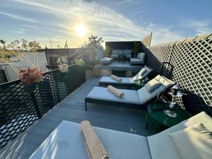 a patio with couches and tables on a balcony at Riad ART DE VIVRE avec Jacuzzi in Marrakech